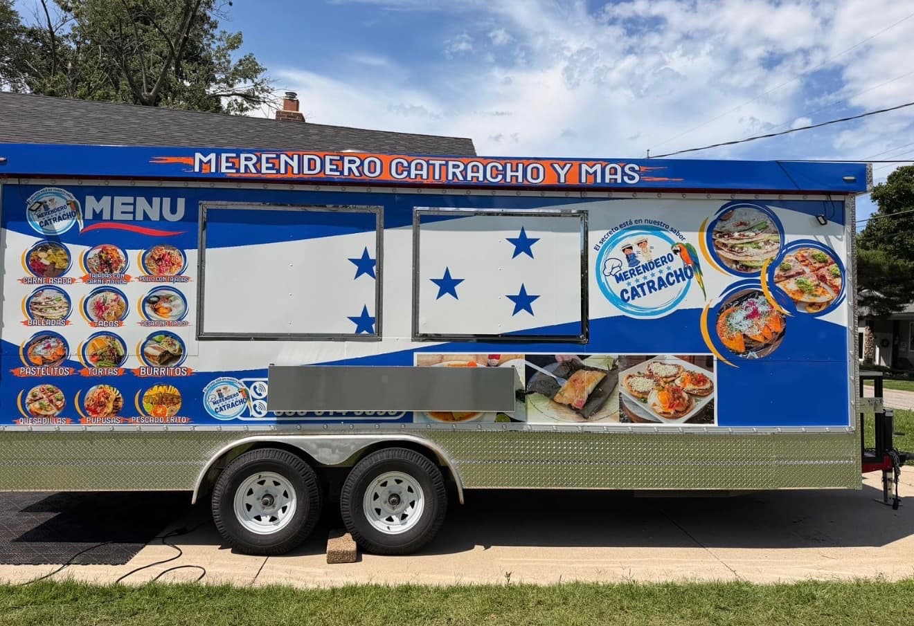 The Merendero Catracho food truck, wrapped in Honduran blue, parked and ready to serve